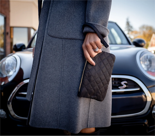 Shot of Woman's hand holding the black Ms. Jetsetter Wristlet and Card Carrying Case